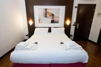 two beds in a hotel room with white shoes on them at Gemini Rooms in Rome