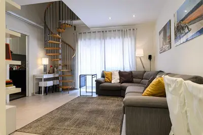 a living room with a couch and a spiral staircase at Casa Tiburtina in Rome