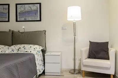 a bedroom with a bed and a chair and a lamp at Casa Tiburtina in Rome