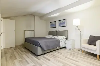 a bedroom with a bed and a couch and a chair at Casa Tiburtina in Rome