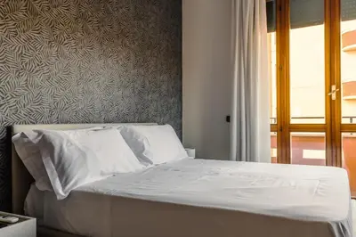a bedroom with a bed with white sheets and a window at Maison Riboty in Rome