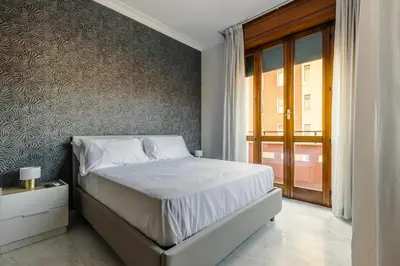a bedroom with a bed and a large window at Maison Riboty in Rome