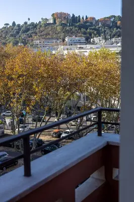 a balcony with a view of a parking lot with trees at Maison Riboty in Rome