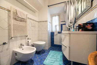 a blue and white bathroom with a sink and a toilet at Rooma Duplex Campo de Fiori in Rome