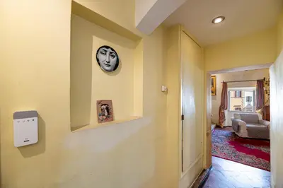 a hallway with a wall with a mask on it at Rooma Duplex Campo de Fiori in Rome