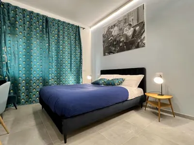 a bedroom with a bed and a blue curtain at Alma Domus Feriae - Roma in Rome