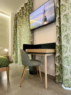 a living room with a piano and a tv on the wall at Alma Domus Feriae - Roma in Rome
