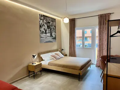 a bedroom with a bed and a lamp and a window at Alma Domus Feriae - Roma in Rome