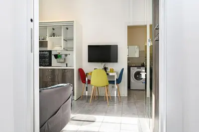 a living room with a table and a yellow chair at Casa Vacanze Marrucini in Rome
