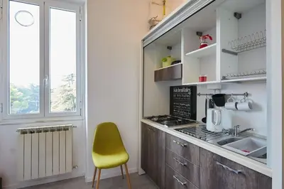 a kitchen with a yellow chair next to a counter at Casa Vacanze Marrucini in Rome
