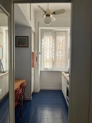 a kitchen with a table and a ceiling fan at Family Apartment by Metro A Vatican Museums in Rome