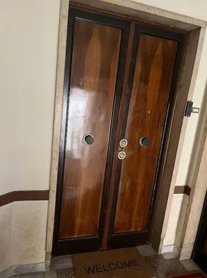 a pair of wooden doors in a building at Family Apartment by Metro A Vatican Museums in Rome