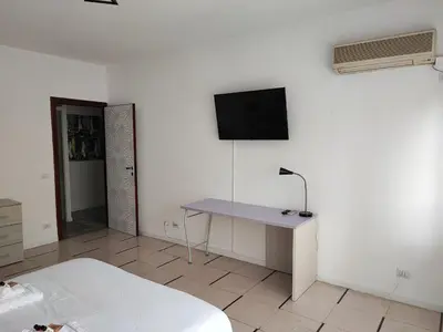 a bedroom with a desk and a tv on the wall at Al Trilocale Romano Metro A in Rome