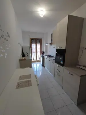 a kitchen with white cabinets and a white counter top at Al Trilocale Romano Metro A in Rome