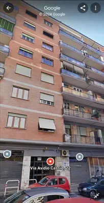a tall building with cars parked in front of it at Al Trilocale Romano Metro A in Rome
