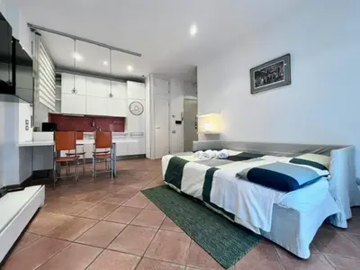 a bedroom with a large bed and a kitchen at Inn Trastevere Home in Rome