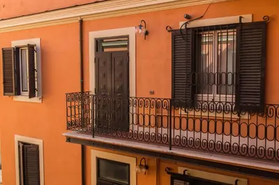 an orange building with a balcony and a door at Martina al Colosseo in Rome