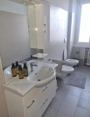 a white bathroom with a sink and a toilet at Suite Guido Reni in Rome
