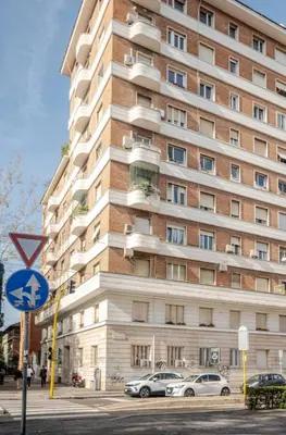 a tall building with cars parked in front of it at Suite Guido Reni in Rome