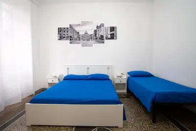 two beds in a white room with blue sheets at Optima mansio in Rome