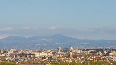 a view of a city with mountains in the background at Panorama Penthouse by Rental in Rome in Rome