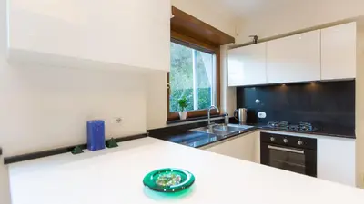 a kitchen with white cabinets and a green plate on a counter at Panorama Penthouse by Rental in Rome in Rome