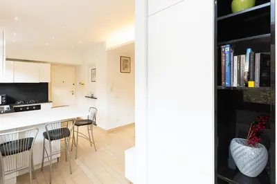a kitchen and living room with a counter and chairs at Panorama Penthouse by Rental in Rome in Rome
