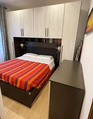 a small bedroom with a bed and a desk at Fabio´s Holiday House in Rome