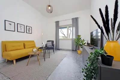 a living room with a yellow couch and a table at Carmens Flat by DomusDimore in Rome