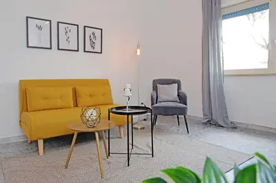 a living room with a yellow couch and a chair at Carmens Flat by DomusDimore in Rome