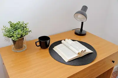 a table with a plate with a book and a lamp at Carmens Flat by DomusDimore in Rome