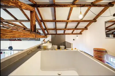 a kitchen with wooden ceilings and a white counter top at Loft in Garbatella in Garbatella