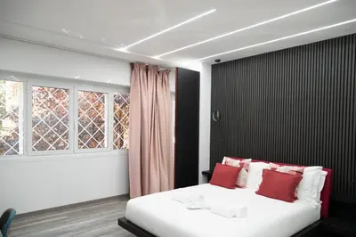 a bedroom with a bed with red pillows and a window at New Luxury Rooms in Rome