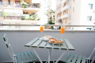 a table with a plate of food and two glasses of orange juice at New Luxury Rooms in Rome