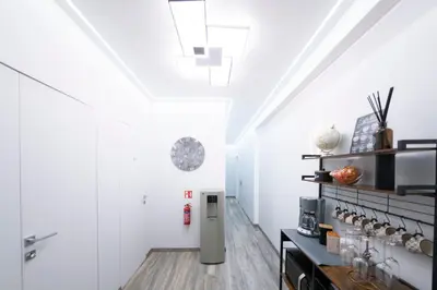 a hallway with white walls and a refrigerator at New Luxury Rooms in Rome