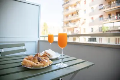 a table with two glasses of orange juice and pastries at New Luxury Rooms in Rome