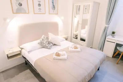 a white bedroom with a bed with two towels on it at Atella Rome Apartment in Rome