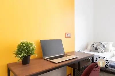 a laptop computer sitting on a wooden desk in a room at Domus Trionfale - 8 min walk to Vatican, 500mt to Metro A, A-C in Rome