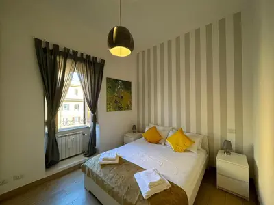 a bedroom with a bed with yellow pillows and a window at Green Oasis in Villa Riccio in Rome