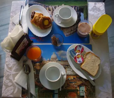 a table topped with plates of food and toast at Tucci's Roma Guest House in Rome