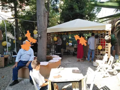 a group of people sitting at tables in front of a market at Tucci's Roma Guest House in Rome