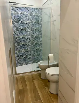 a bathroom with a toilet and a glass shower at Dimora Sistina Roma in Rome