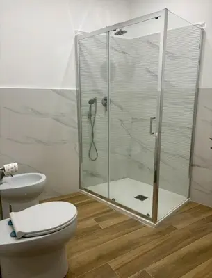 a bathroom with a toilet and a glass shower at Dimora Sistina Roma in Rome