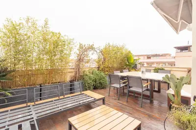 a patio with a table and benches on a balcony at Elegant apartment metro A - by OpenRoma in Rome