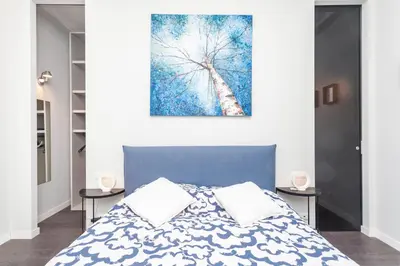 a bedroom with a blue bed and a painting on the wall at Elegant apartment metro A - by OpenRoma in Rome