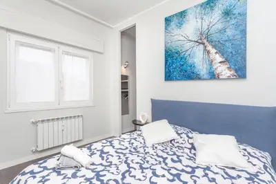 a bedroom with a blue and white bed and a painting at Elegant apartment metro A - by OpenRoma in Rome