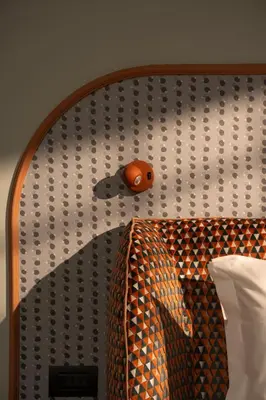 a headboard with an orange object on a wall at Cloud 7 Roma Hotel in Rome