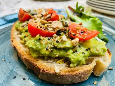 a piece of bread with guacamole on a blue plate at Cloud 7 Roma Hotel in Rome