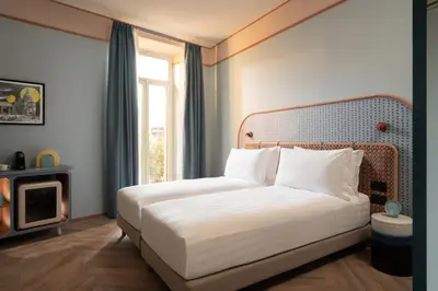 a bedroom with a white bed with a window at Cloud 7 Roma Hotel in Rome