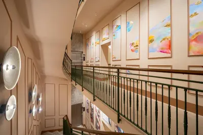 a staircase in a building with paintings on the walls at Cloud 7 Roma Hotel in Rome